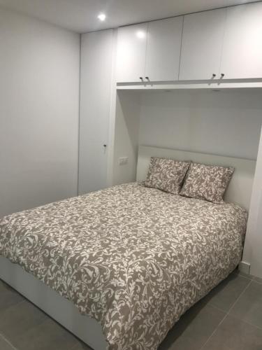 Cama en habitación con armarios blancos en Casa en CARABAÑA a 30 minutos de MADRID, en Carabaña