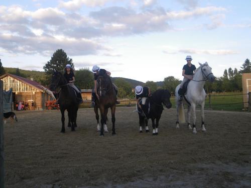 un groupe de personnes à cheval sur un champ de terre dans l'établissement Chalet de campagne, à Sancey-le-Grand