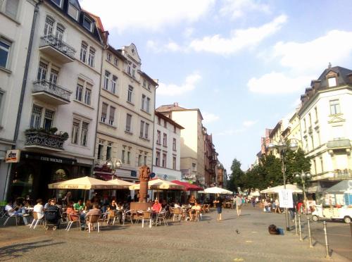 a city street with tables and chairs and buildings at CityCentre room for 1 female persons - alternative plus 1 child in Frankfurt/Main