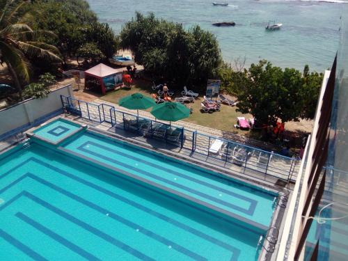 a swimming pool with a view of a beach and the ocean at Paradise Beach Resort & Diving school in Mirissa