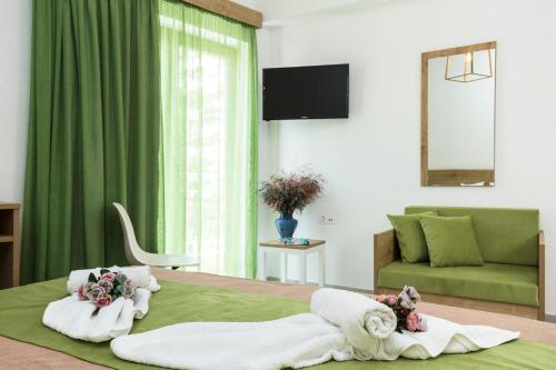 - une chambre avec un lit, des serviettes et un canapé dans l'établissement Castell Hotel, à Kíssamos