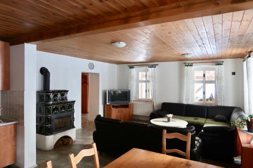 a living room with a couch and a stove at Chata U Zmrzlyho in Vrchlabí