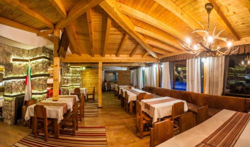 Un restaurante con techos de madera y mesas y sillas. en Boriki Complex, en Pamporovo