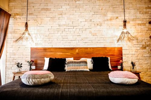 a bedroom with a large bed with two pillows on it at XscapeTulum in Tulum
