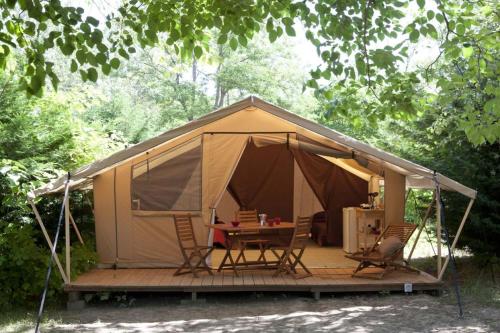 uma tenda com cadeiras e uma mesa em Drome esprit nature em Le Poët-Célard