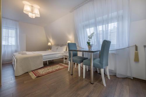 a bedroom with a bed and a table and chairs at Kesminta Apartments in Vilnius