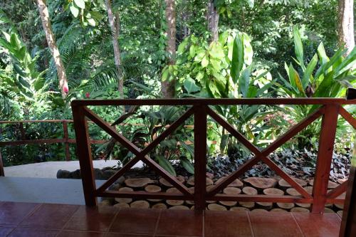 a wooden bench in front of a garden with trees at Villas en el Bosque in Ojochal