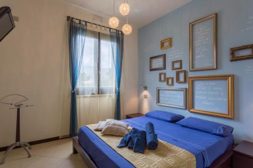 a bedroom with a bed with blue sheets and a window at Karma B&B in San Vito lo Capo