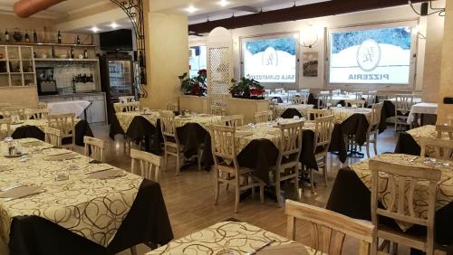a dining room with tables and chairs in a restaurant at Hotel Ristorante Tre Leoni in Somma Lombardo