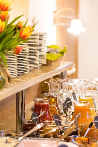 a buffet line with dishes and glasses and flowers at Hotel Diana in Feldberg