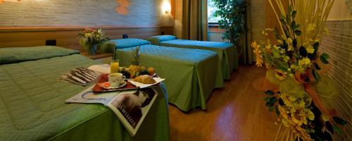 a hotel room with two beds and a table with a tray of food at Hotel Ristorante Tre Leoni in Somma Lombardo