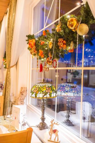 a window with a christmas wreath and two vases on a table at Hotel Diana in Feldberg