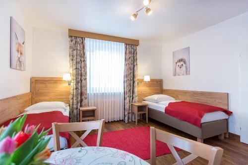 Habitación de hotel con 2 camas y mesa en Hotel Diana en Feldberg