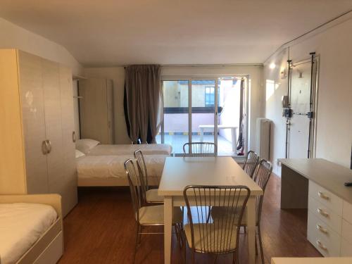 ein kleines Zimmer mit einem Bett, einem Tisch und Stühlen in der Unterkunft M14 Duomo Apartments in Padua