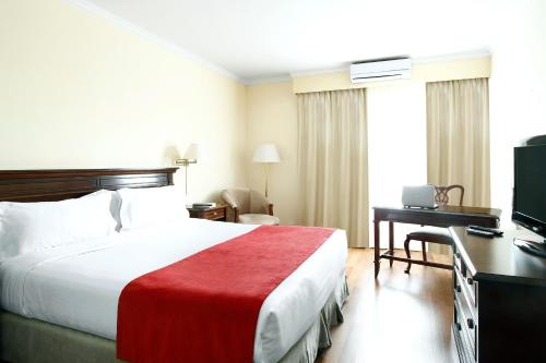 Habitación de hotel con cama, escritorio y TV. en Cyan Américas Towers Hotel en Buenos Aires