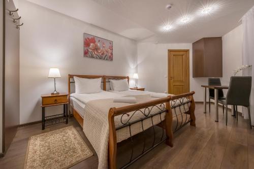 a bedroom with a bed and a desk and a table at Kesminta Apartments in Vilnius