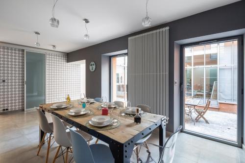 une salle à manger avec une table et des chaises en bois dans l'établissement LE RIAD - Loft de 230 m2 au cœur de Nantes, à Nantes