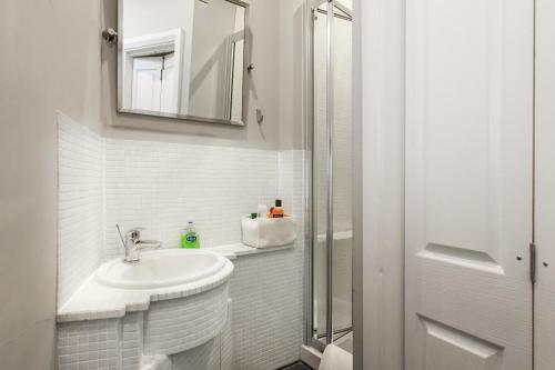 ein weißes Badezimmer mit einem Waschbecken und einem Spiegel in der Unterkunft Trendy 2 Bedroom apartment in vibrant Shoreditch, central London zone 1 free WiFi - sleeps 4+2 in London