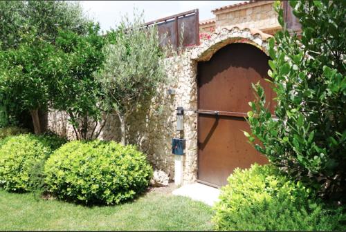 a large brown garage door in a brick building at Chez Virginie in Porto-Vecchio