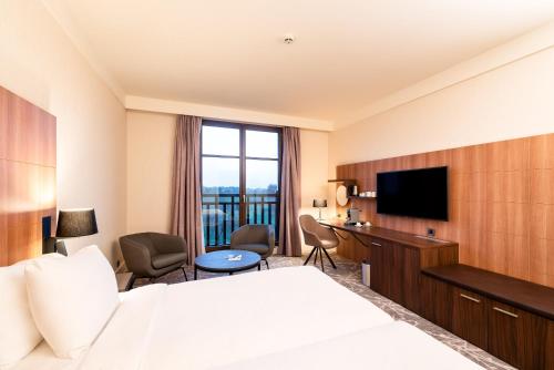 a hotel room with a bed and a flat screen tv at Radisson Blu Hotel Paris, Marne-la-Vallée in Magny-le-Hongre