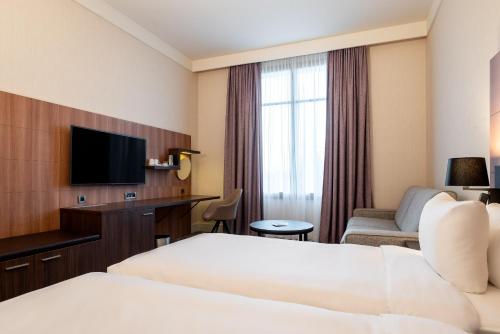 a hotel room with a bed and a tv at Radisson Blu Hotel Paris, Marne-la-Vallée in Magny-le-Hongre