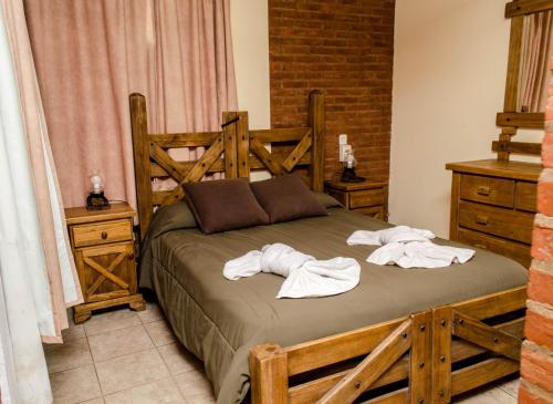 een slaapkamer met een bed met handdoeken erop bij Cabañas y Apart Utopia in Mar de las Pampas