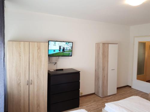 AB Apartment Objekt 24 في شتوتغارت: غرفة نوم مع تلفزيون على الحائط وخزانة