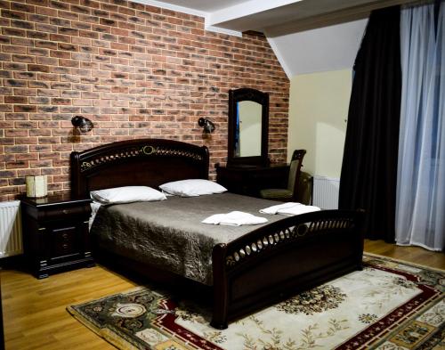a bedroom with a bed and a brick wall at Recreation Complex Sunny Resort in Polyana