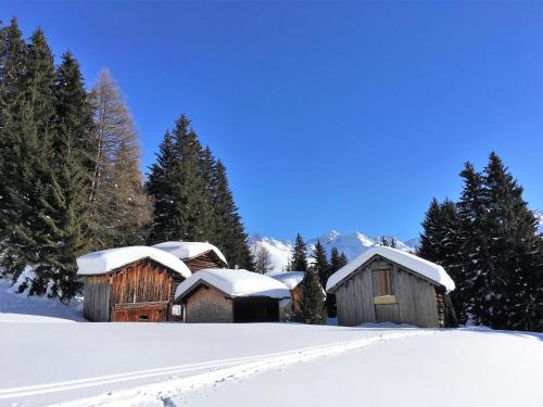 a couple of wooden buildings covered in snow at Haus Ladner in See