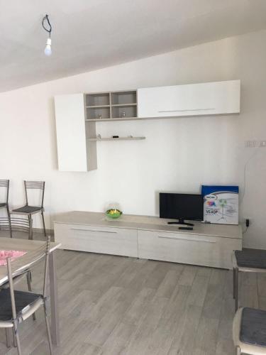 a living room with a flat screen tv on a white wall at Residenze Cutrì Casa Vacanze Cilento by ElodeaGroup in Pisciotta