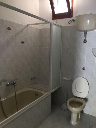 a bathroom with a tub and a toilet and a sink at Residenze Cutrì Casa Vacanze Cilento by ElodeaGroup in Pisciotta
