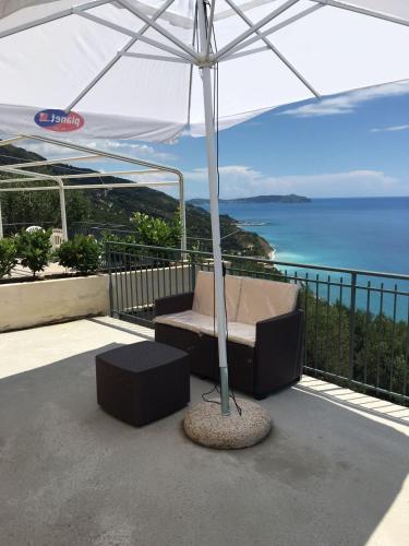 a patio with an umbrella and a chair under a table at Residenze Cutrì Casa Vacanze Cilento by ElodeaGroup in Pisciotta