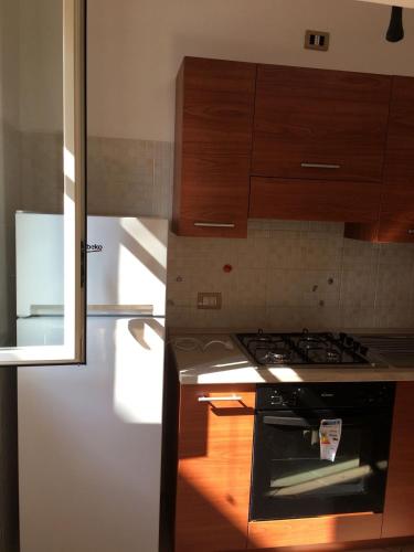 a kitchen with a stove and a refrigerator at Residenze Cutrì Casa Vacanze Cilento by ElodeaGroup in Pisciotta