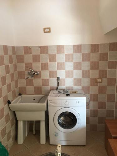 a bathroom with a washing machine and a sink at Residenze Cutrì Casa Vacanze Cilento by ElodeaGroup in Pisciotta