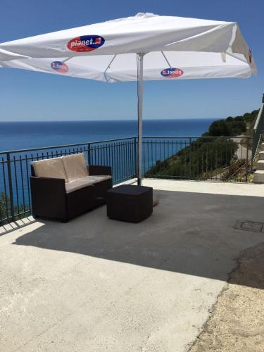 a white umbrella and a chair under a table at Residenze Cutrì Casa Vacanze Cilento by ElodeaGroup in Pisciotta