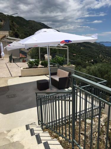 a white umbrella sitting on top of a table at Residenze Cutrì Casa Vacanze Cilento by ElodeaGroup in Pisciotta