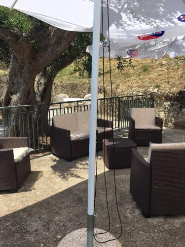 a swing with chairs and an umbrella on a patio at Residenze Cutrì Casa Vacanze Cilento by ElodeaGroup in Pisciotta