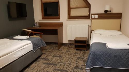a hotel room with two beds and a desk at Centrum Promocji Leśnictwa w Mucznem in Lutowiska