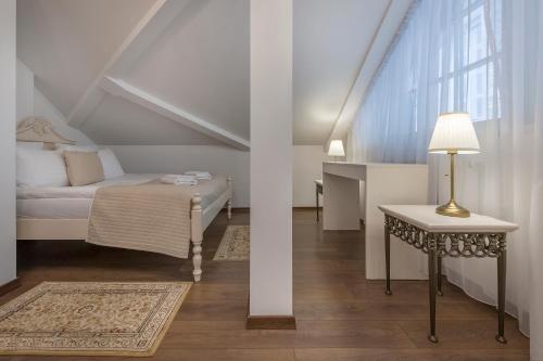 a bedroom with a bed and a table and a window at Kesminta Apartments in Vilnius