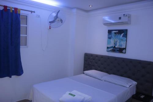 a bedroom with a bed with a blue light at Hotel Malibu in San Juan Nepomuceno