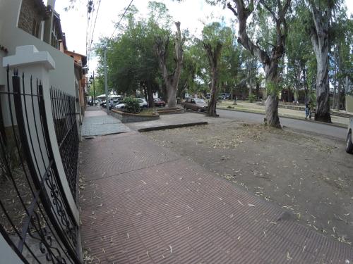 una acera de ladrillo junto a una valla al lado de una calle en Apartamento San Martin en Salta