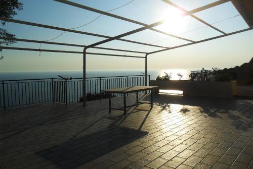 a picnic table on a patio with a view of the ocean at Residenze Cutrì Casa Vacanze Cilento by ElodeaGroup in Pisciotta