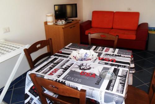 a room with a table with a pile of magazines at Residenze Cutrì Casa Vacanze Cilento by ElodeaGroup in Pisciotta