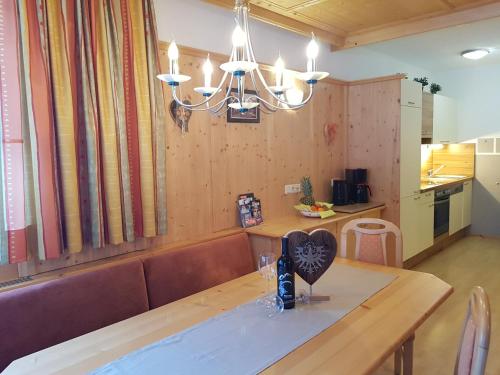 ein Esszimmer mit einem Tisch mit einer Herzvase darauf in der Unterkunft Alpina Appartement in Sankt Leonhard im Pitztal