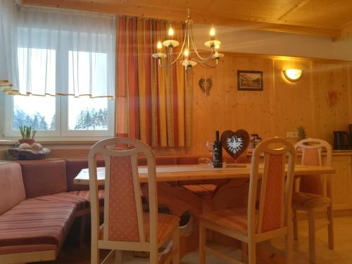 a dining room with a wooden table and chairs at Alpina Appartement in Sankt Leonhard im Pitztal