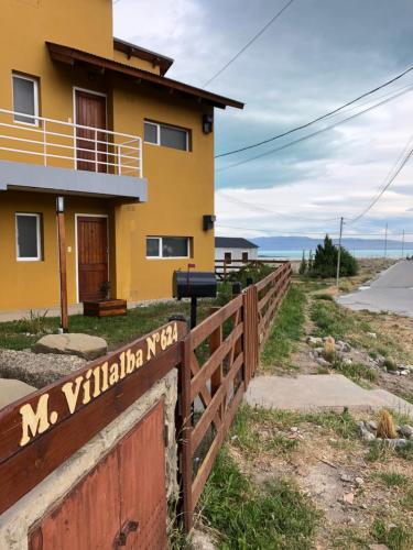 a yellow house with a fence in front of it at Mi casa es tu casa - PC Home in El Calafate