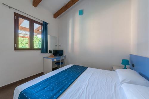 a bedroom with a large bed and a window at Green Village in Marina di Camerota