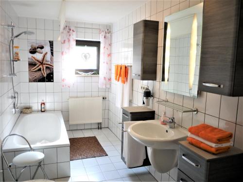 a white bathroom with a tub and a sink at Ferienwohnung-Apartment Regnitztal in Buttenheim