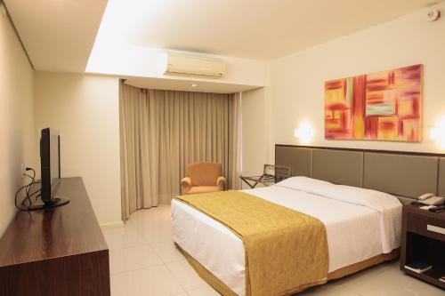 a hotel room with a bed and a television at Rafain Palace Hotel & Convention Center in Foz do Iguaçu