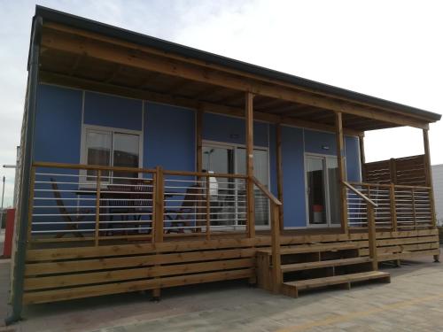 a house with a large porch and a blue building at Camping Verona Village in Verona